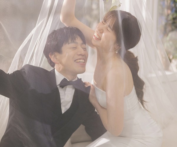 ベールの中でほほ笑む新郎新婦